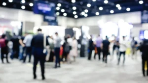 Blurred exhibition event in hall with many people on background. many businessmen are walking in the seminar